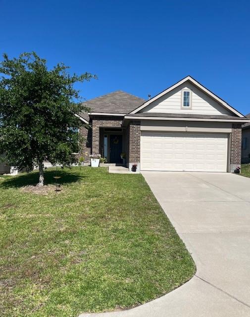 ranch-style home with concrete driveway, brick siding, a front yard, and a garage