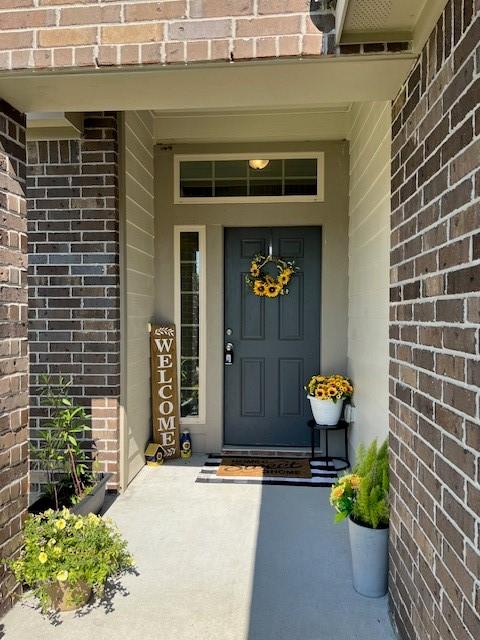 doorway to property with brick siding