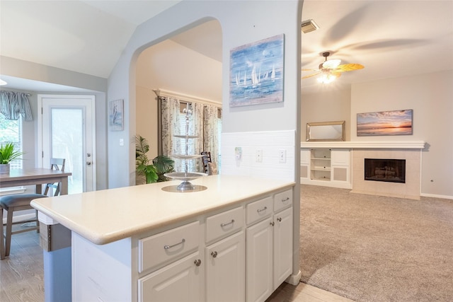 834 Arbor Pne, Tomball, TX 77375 - kitchen featuring vaulted ceiling, white cabinetry, ceiling fan, a fireplace, and light countertops