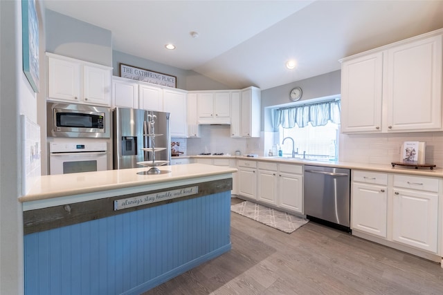 834 Arbor Pne, Tomball, TX 77375 - kitchen with appliances with stainless steel finishes, a sink, vaulted ceiling, white cabinetry, and decorative backsplash