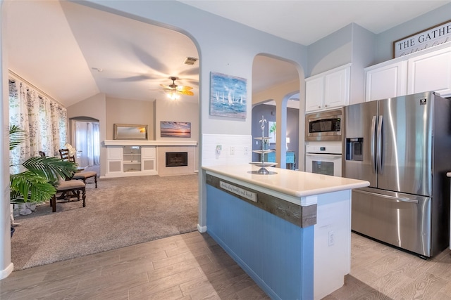 834 Arbor Pne, Tomball, TX 77375 - kitchen with appliances with stainless steel finishes, arched walkways, light wood finished floors, white cabinets, and a ceiling fan