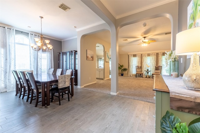 834 Arbor Pne, Tomball, TX 77375 - dining room featuring a chandelier, light wood-type flooring, arched walkways, plenty of natural light, and crown molding