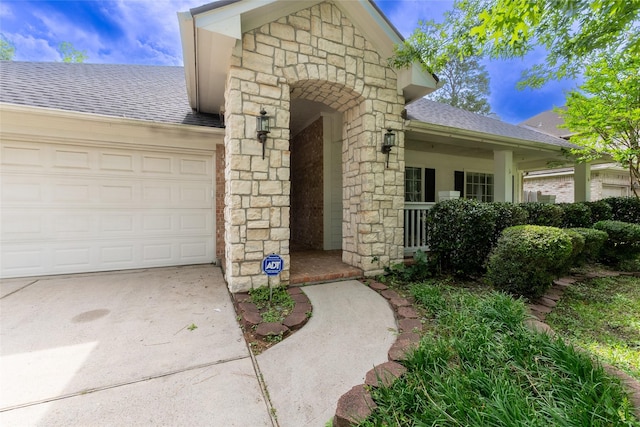 834 Arbor Pne, Tomball, TX 77375 - property entrance featuring a shingled roof, stone siding, an attached garage, and concrete driveway