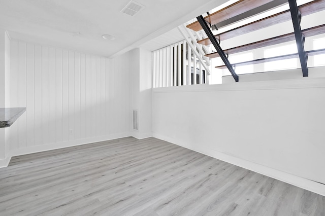 spare room featuring visible vents, baseboards, and wood finished floors