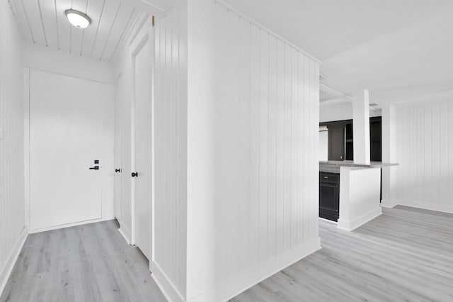 corridor featuring baseboards and light wood-type flooring