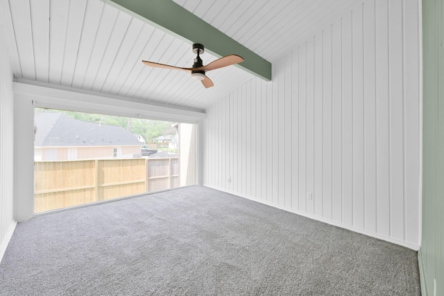 unfurnished room featuring carpet floors, a ceiling fan, and beamed ceiling