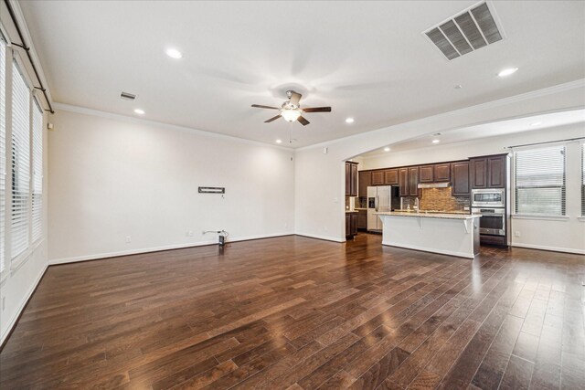 2707 Kings Retreat Cir, Kingwood, TX 77345 - unfurnished living room with crown molding, baseboards, ceiling fan, and visible vents