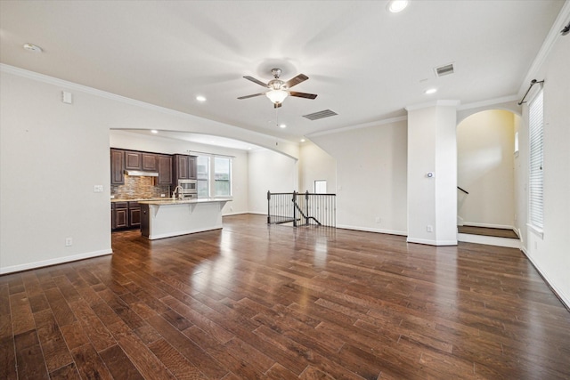 2707 Kings Retreat Cir, Kingwood, TX 77345 - unfurnished living room featuring crown molding, arched walkways, a ceiling fan, and visible vents