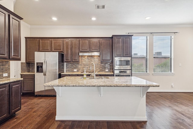 2707 Kings Retreat Cir, Kingwood, TX 77345 - kitchen featuring crown molding, dark brown cabinets, a sink, stainless steel appliances, and under cabinet range hood