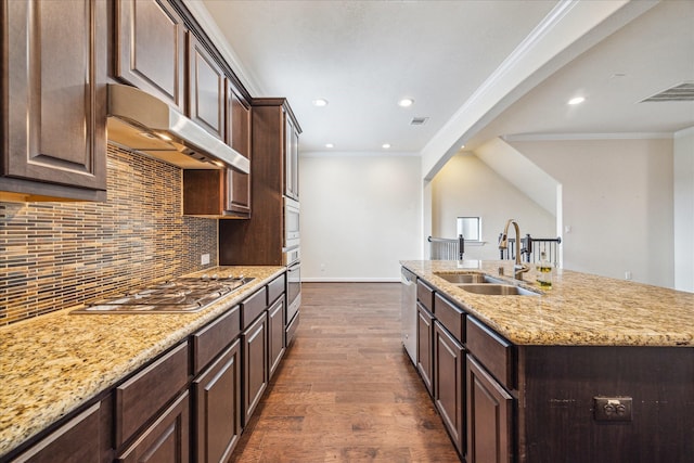 2707 Kings Retreat Cir, Kingwood, TX 77345 - kitchen featuring dark wood-style flooring, under cabinet range hood, tasteful backsplash, a sink, and stainless steel appliances