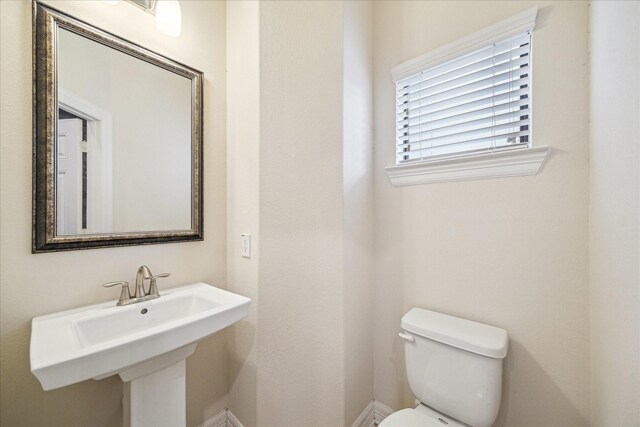 2707 Kings Retreat Cir, Kingwood, TX 77345 - bathroom with a sink, baseboards, and toilet