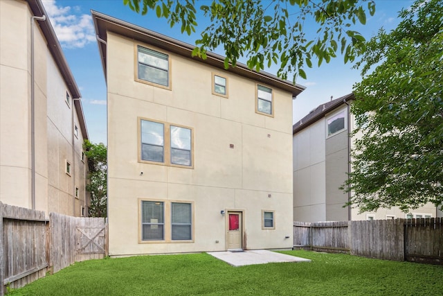 2707 Kings Retreat Cir, Kingwood, TX 77345 - back of property featuring a lawn, a patio, stucco siding, and a fenced backyard