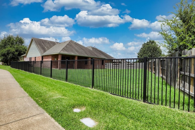 exterior space with brick siding, fence, and a yard