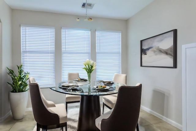 dining area featuring baseboards, light tile patterned flooring, and visible vents