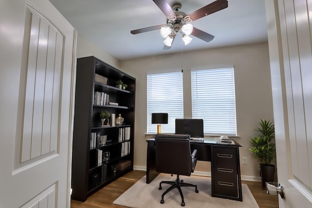 office area featuring baseboards, ceiling fan, and wood finished floors