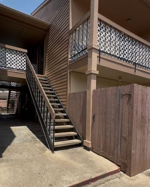 view of property with fence and stairs