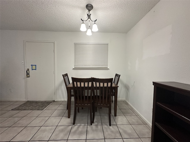 dining space with baseboards, a textured ceiling, a notable chandelier, and light tile patterned floors