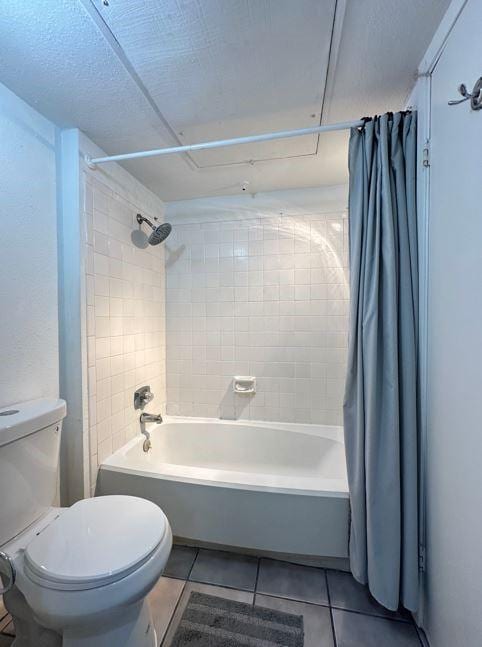 bathroom with tile patterned flooring, toilet, and shower / bath combination with curtain