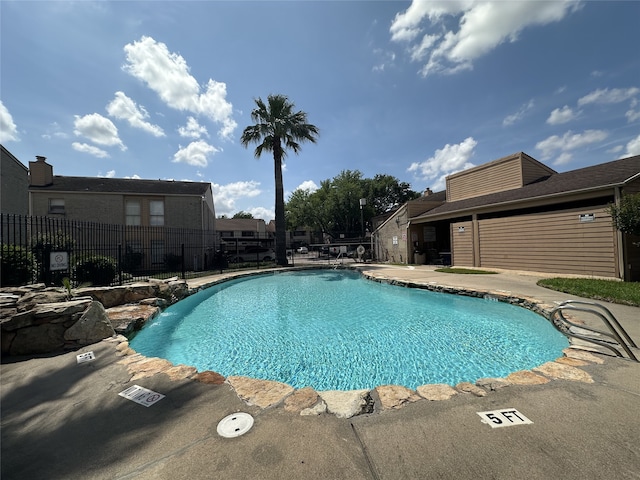 pool with fence and a patio