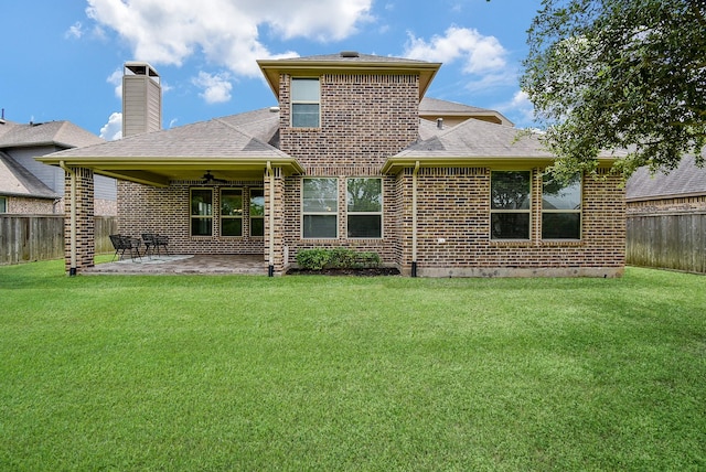 back of house with brick siding, a fenced backyard, a patio area, and a yard