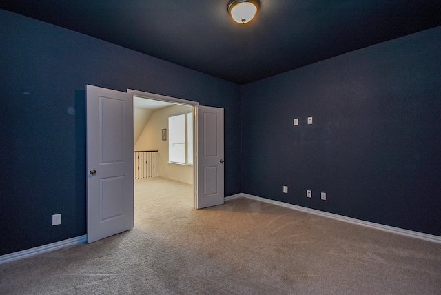 unfurnished room with baseboards and carpet