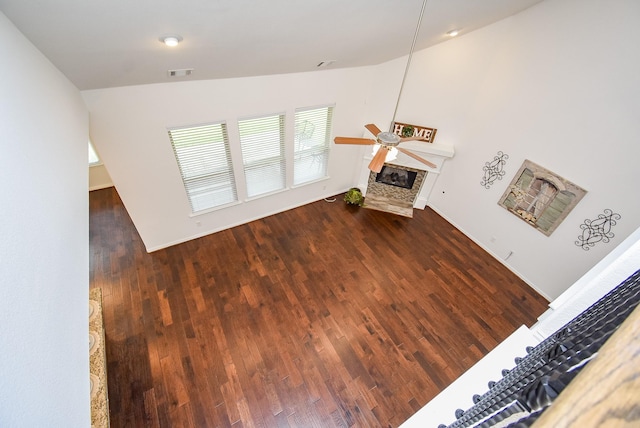 living area featuring a ceiling fan, visible vents, wood finished floors, and a fireplace