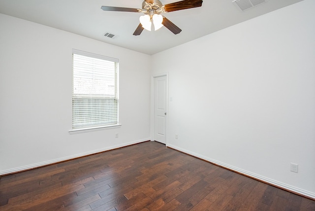 spare room featuring a ceiling fan, baseboards, visible vents, and dark wood finished floors
