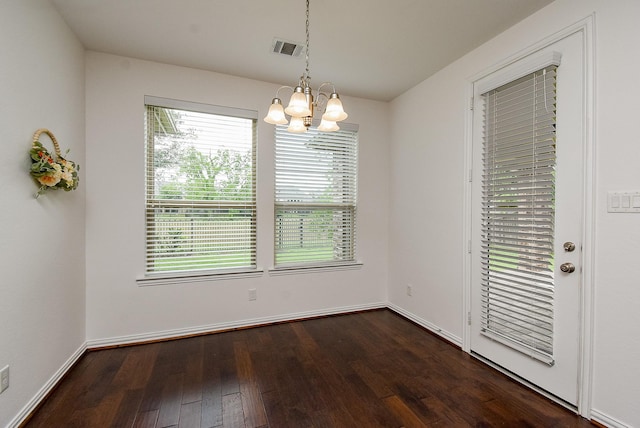 unfurnished dining area featuring a chandelier, dark wood-style floors, and a wealth of natural light