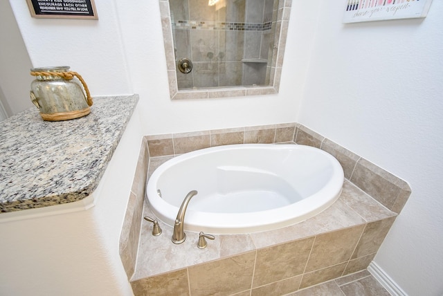 bathroom with tiled shower and a garden tub