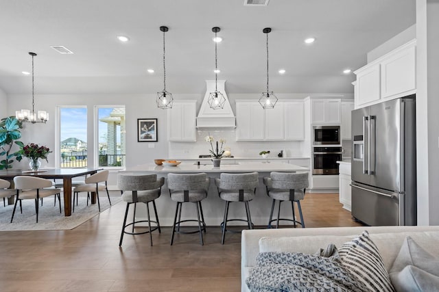 kitchen featuring visible vents, appliances with stainless steel finishes, recessed lighting, and premium range hood