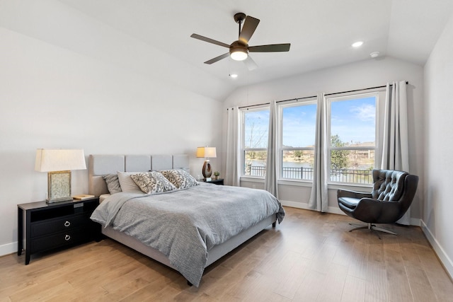 bedroom with baseboards, vaulted ceiling, and light wood-type flooring