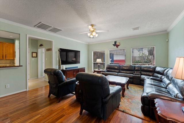 living area with a ceiling fan, a textured ceiling, visible vents, and wood finished floors