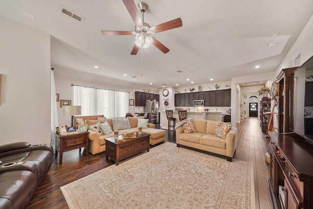 living room featuring a ceiling fan, visible vents, dark wood finished floors, and recessed lighting