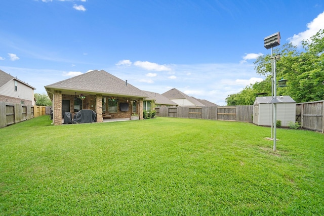 view of yard with a fenced backyard, an outbuilding, a patio area, and a storage shed