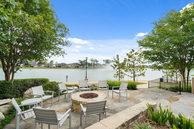 view of patio with a water view and an outdoor fire pit