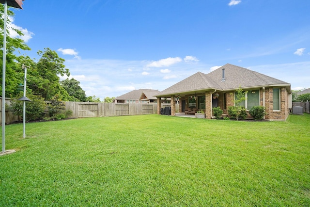 view of yard with cooling unit, a fenced backyard, and a patio area