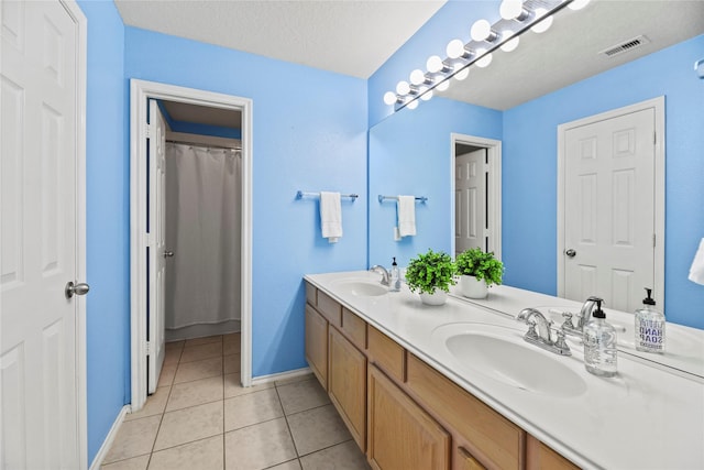 full bathroom with baseboards, tile patterned floors, visible vents, and a sink