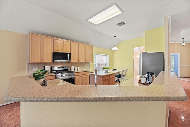 kitchen featuring decorative backsplash, visible vents, appliances with stainless steel finishes, lofted ceiling, and light brown cabinets