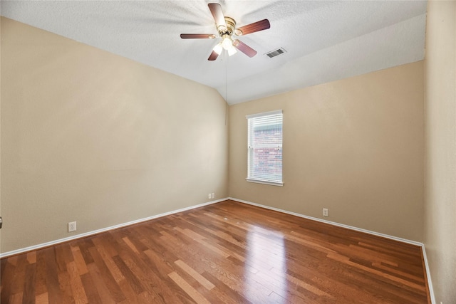 spare room with baseboards, ceiling fan, wood finished floors, and visible vents