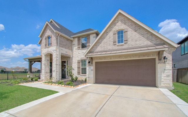 french provincial home featuring fence, stone siding, and concrete driveway