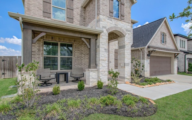 view of front facade with brick siding, fence, stone siding, and concrete driveway