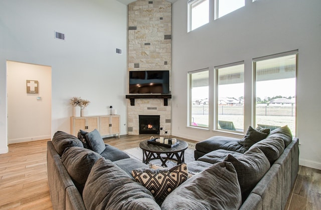 living room featuring plenty of natural light, baseboards, a high ceiling, and visible vents