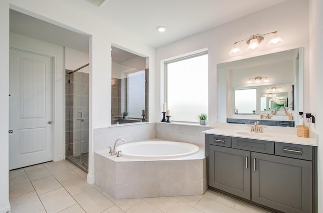 full bath featuring vanity, tile patterned flooring, a shower stall, and a garden tub