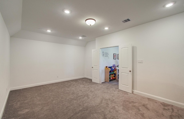 carpeted spare room featuring recessed lighting, baseboards, visible vents, and lofted ceiling