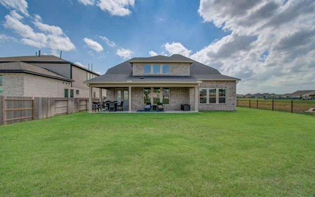 rear view of house featuring brick siding, a fenced backyard, a patio area, central air condition unit, and a lawn