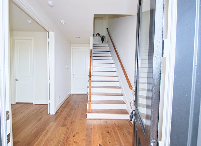 stairway with wood-type flooring and baseboards