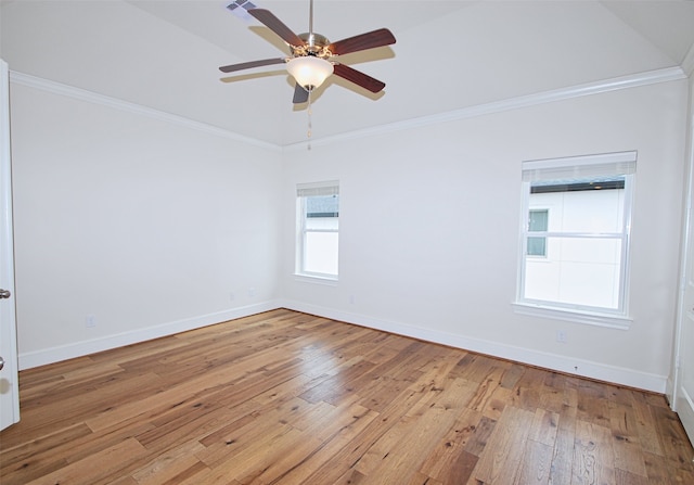 spare room featuring crown molding, baseboards, a ceiling fan, and light wood-type flooring