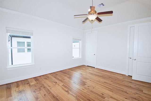 spare room with crown molding, ceiling fan, baseboards, and light wood-style floors