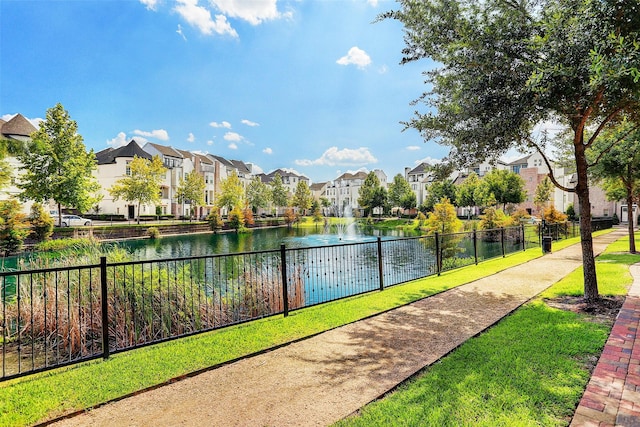 view of community with a residential view, fence, and a water view