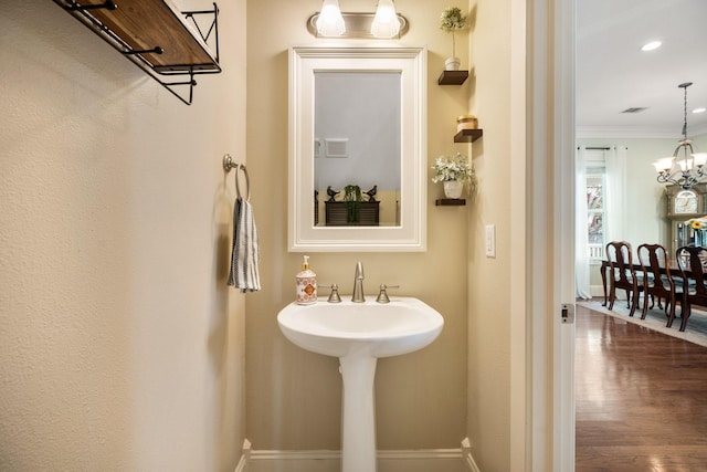 8 Latitude Ln, Galveston, TX 77554 - bathroom featuring an inviting chandelier, ornamental molding, wood finished floors, baseboards, and recessed lighting